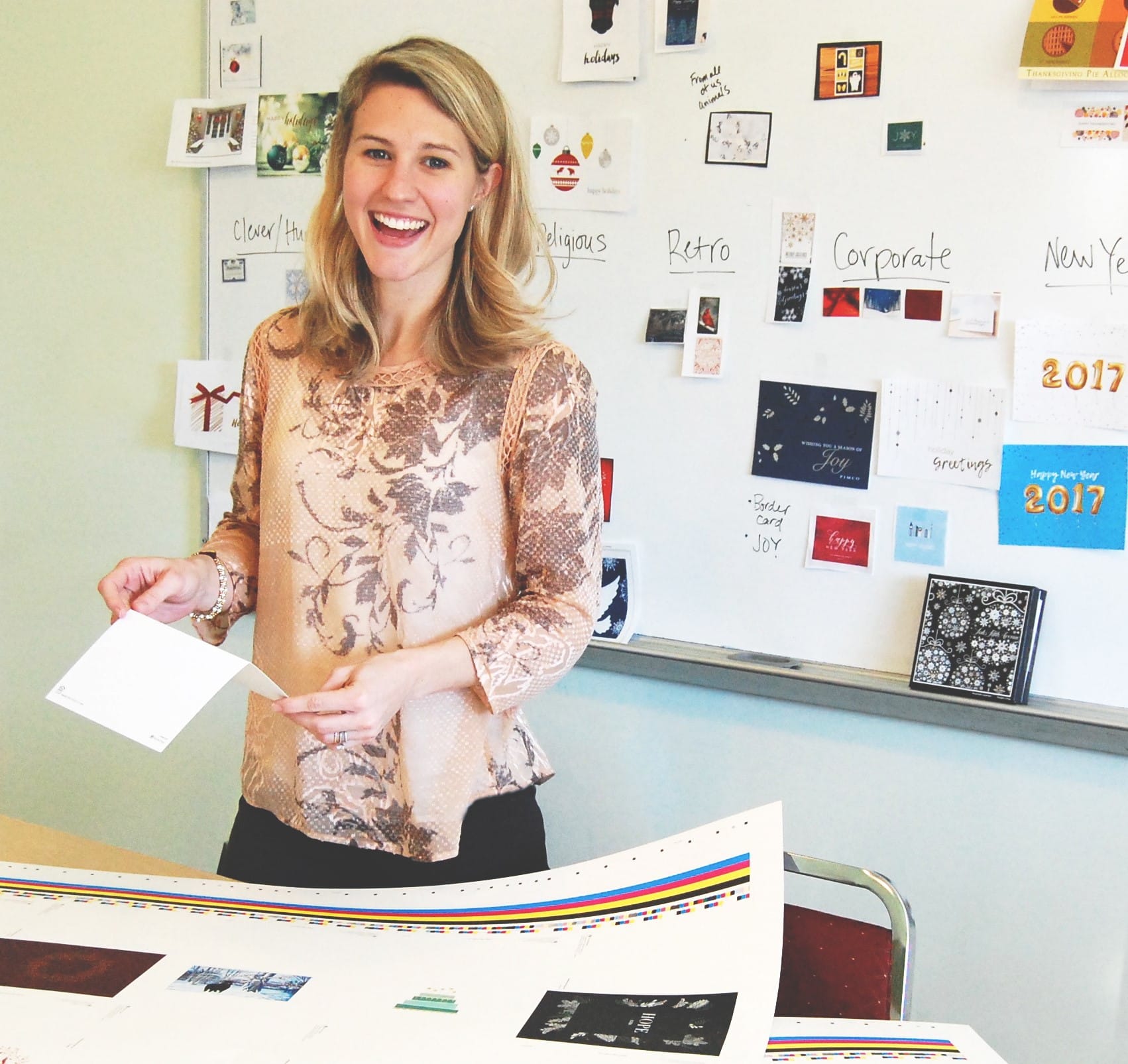 This is a picture of Mary Ellen Harden standing in her office holding a greeting card.