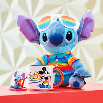 Stitch plush in rainbow Pride gear with Mickey Mouse Pride mug